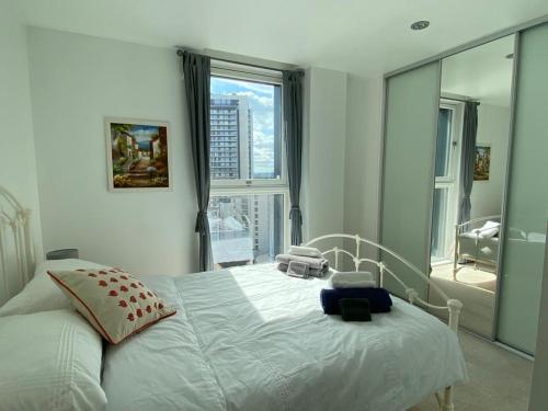 1 dormitorio con cama blanca y ventana grande en Morden 2bed2bath London Zone2 City/River View Home, en Londres