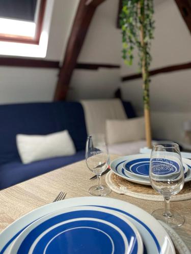 - une table avec des assiettes bleues et blanches et des verres à vin dans l'établissement Studio Centre-ville - Tout équipé, à Bourges