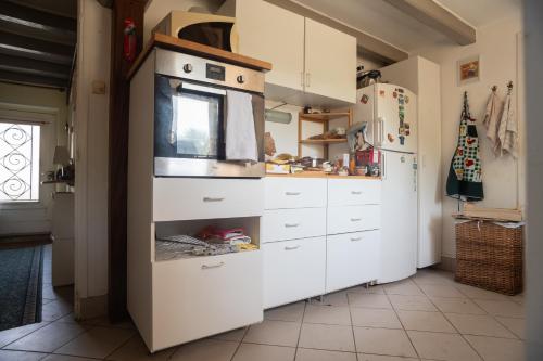 une cuisine avec une cuisinière et un réfrigérateur dans l'établissement Maison de famille du pont Millénaire, à Ahun