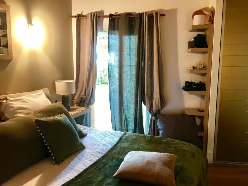 1 dormitorio con 1 cama y una ventana con cortinas en VILLA SANTONI en Grosseto-Prugna