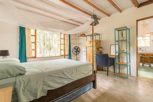 1 dormitorio con 1 cama y escritorio en una habitación en Casa Mazam, en Talamanca