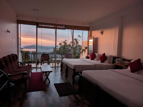 een hotelkamer met 3 bedden en uitzicht op de bergen bij Nilowin Glenanore Guesthouse in Haputale