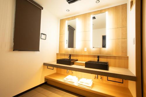 une salle de bain avec deux lavabos et un miroir dans l'établissement 奈良旅館別館 Sweet 螢 源, à Nara