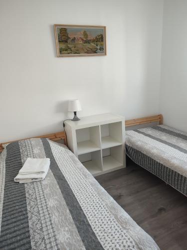 1 dormitorio con 2 camas y mesita de noche entre ellas en Pokoje_Zbąszyń, en Zbąszyń