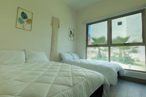 a bedroom with two beds and a large window at Villa Cala Marina + Jacuzzi in Colón