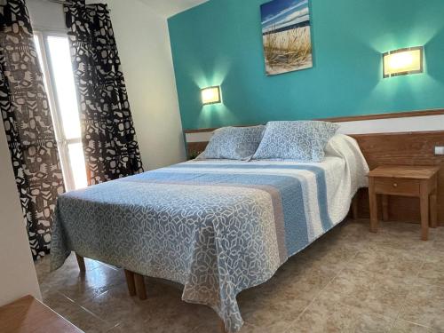 una camera con un letto con una parete blu di VILLA LUZ SUITE a Maspalomas
