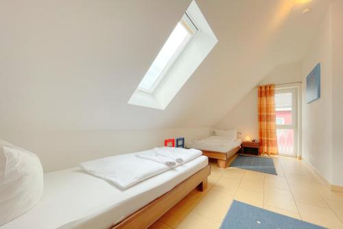 1 dormitorio en el ático con cama y ventana en An den Kreischen 28 Ferienhaus Engel, en Ückeritz