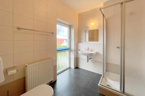 a bathroom with a shower and a toilet and a sink at An den Kreischen 28 Ferienhaus Engel in Ueckeritz