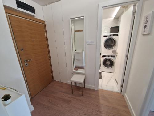 a bathroom with a door and a washer and dryer at Royal apartment Sava river Blok 70 in Ada Ciganlija
