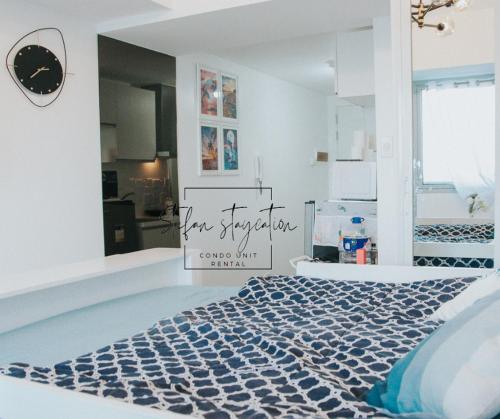Stefan Staycation @ Azure North في سان فيرناندو: غرفة بها سرير مع علامة عليه