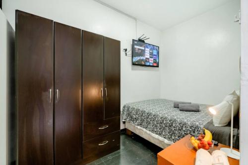 1 dormitorio con 1 cama y un gran armario de madera en Room 5 Star Miraflores, en Lima