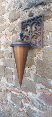 a street light on the side of a stone wall at El Racó dels Mussols 2 in Adri