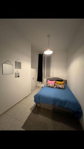 een slaapkamer met een blauw bed in een witte kamer bij Appartement centre ville de Saint Quentin in Saint-Quentin