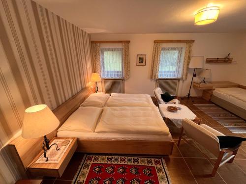 a small bedroom with two beds and a couch at Pension Hattinger in Maria Alm am Steinernen Meer