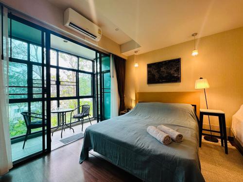 een slaapkamer met een bed en een groot raam bij Brand New Naithon Condo C411 in Nai Thon Beach