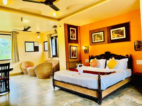 Udai Valley Resort- Top Rated Resort in Udaipur with mountain view في أودايبور: غرفة نوم مع سرير وغرفة معيشة