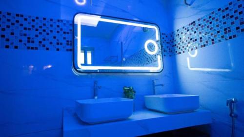 a blue bathroom with a sink and a mirror at Presken Waters in Lagos