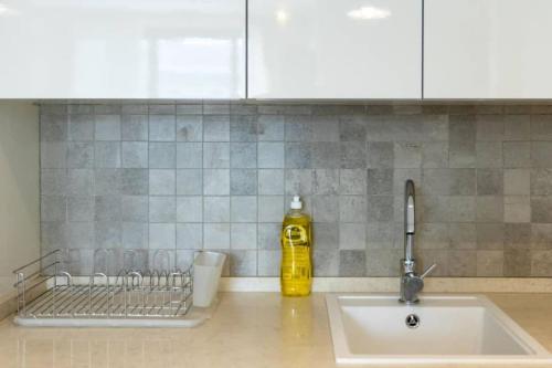 a kitchen counter with a sink and a yellow bottle at Central 2 Bed Apartment in Cantonments