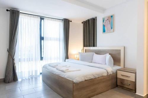 a bedroom with a large bed and a large window at Central 2 Bed Apartment in Cantonments