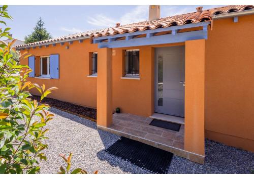 ein Haus mit einem orangenen Haus mit einer Eingangstür in der Unterkunft LA PITCHOULINE in Saint-Saturnin-dʼApt