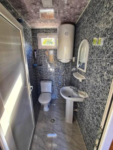 a small bathroom with a toilet and a sink at Racha Nanida in Agara