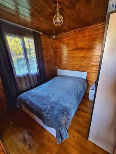 a bedroom with a bed in a wooden cabin at Racha Nanida in Agara