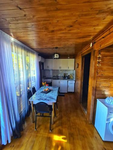a dining room with a table and chairs and a kitchen at Racha Nanida in Agara
