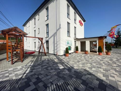 a large white building with a playground in front of it at ALPIN rooms in Topliţa