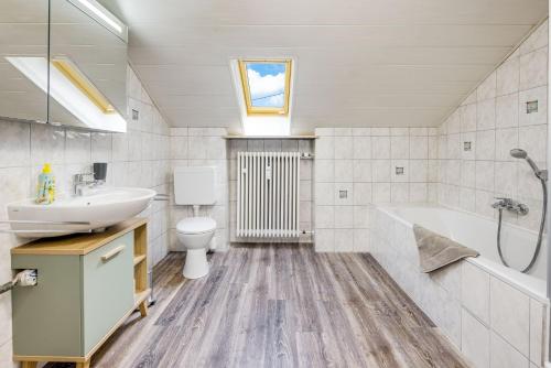 uma casa de banho com um lavatório, uma banheira e um WC. em Monkey Flat 2 Zimmer Wohnung in Vohburg mit Büro em Vohburg an der Donau