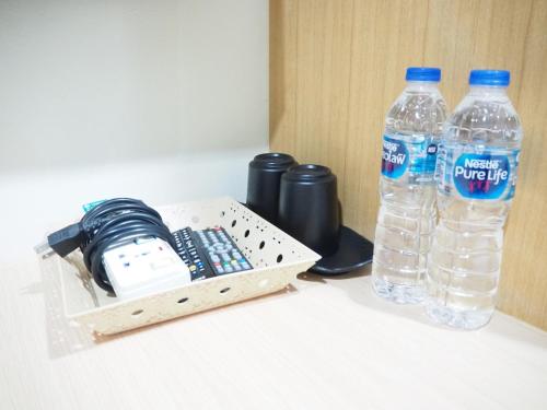 two bottles of water sitting next to a box of water at NANA BEST INN HOTEL in Makkasan