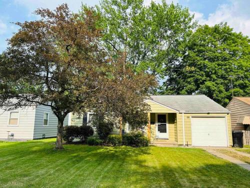 a yellow house with a tree in a yard at Close to airport* Pets*Fenced yard*A/C & Fast WIFI in Cleveland