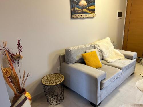 a living room with a blue couch with yellow pillows at Aires del Norte Apart in San Miguel de Tucumán