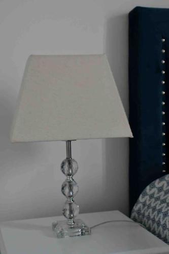 une lampe posée sur une table à côté d'un lit dans l'établissement Studio Le Mansart au pied du Château Insead, à Fontainebleau