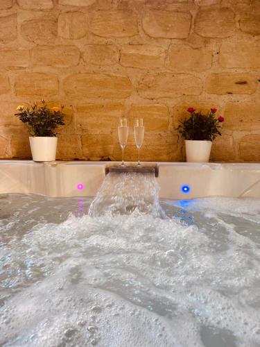 - deux verres à champagne assis au-dessus d'un bain à remous dans l'établissement Feifei's Home & Spa - Luxe 10 min Paris, à Asnières-sur-Seine