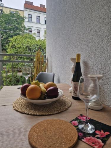 uma mesa com um prato de frutas e uma garrafa de vinho em La Grande em Viena