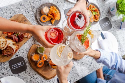 a group of people holding up drinks at a table with food at London Marriott Hotel Canary Wharf in London