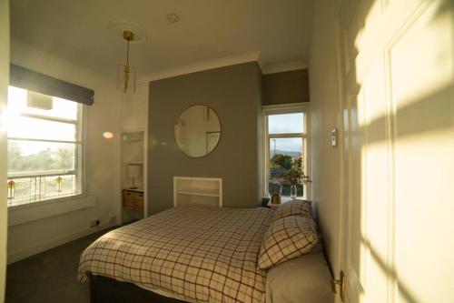 Un dormitorio con una cama y un espejo en la pared. en Georgian Gem Free Parking &Views, en Bath