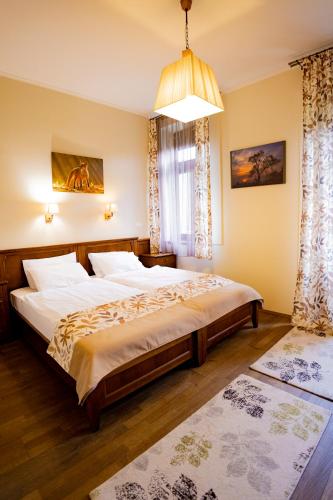 a bedroom with two beds and a chandelier at Sasréti Vadászkastély Almamellék in Almamellék