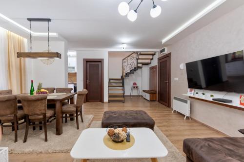 a living room with a table and a dining room at Apartman Gačanović Lux in Zlatibor