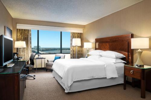 a hotel room with a large bed and a television at Sheraton Memphis Downtown Hotel in Memphis