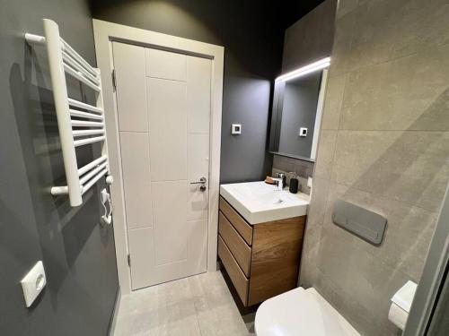 een badkamer met een wit toilet en een wastafel bij Nice apartment with a balcony by the sea. in Ķesterciems