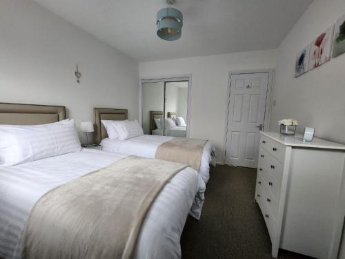 1 Schlafzimmer mit 2 Betten und einer Kommode in der Unterkunft 10 Ladyknowe court in Moffat