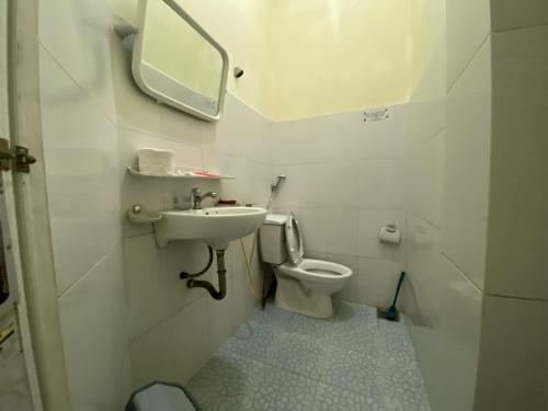 a bathroom with a toilet and a sink and a mirror at Khách Sạn Minh Nghĩa Trung Tâm Đà Lạt - 밍냐 저럄한 호텔 in Da Lat
