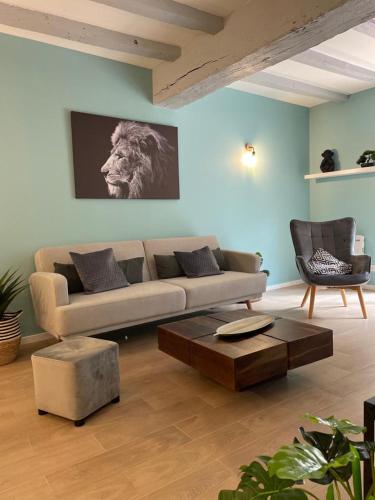una sala de estar con sofá y un león en la pared en Casa Luna, Votre Maison Familiale avec son jardin privé en Plein Cœur de Ville en Bourges