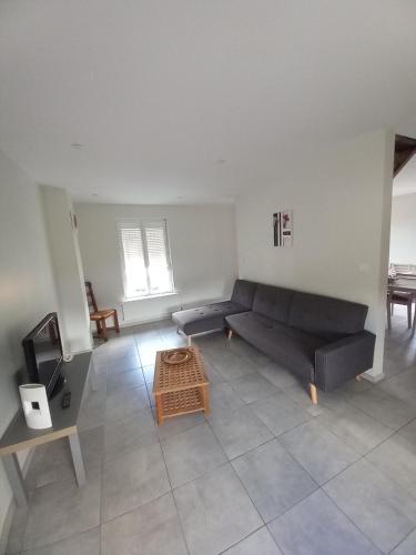 a living room with a black couch and a table at maison du chemin de fer in Grandcourt