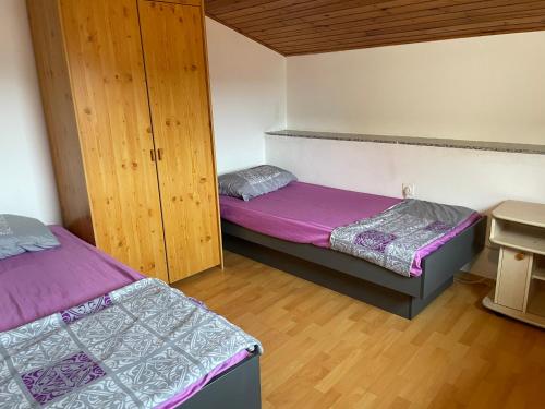 two beds in a room with purple sheets at Apartmaji Sara, Izola - Isola in Izola