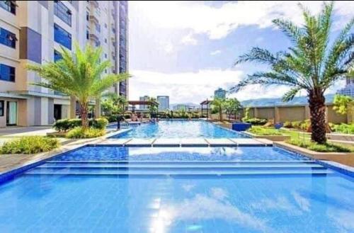 a large swimming pool in a building with palm trees at Ghabian Property in Cebu City