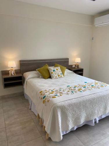 Un dormitorio con una gran cama blanca con flores. en Apart Moderno a Estrenar Barrio Sur en San Miguel de Tucumán