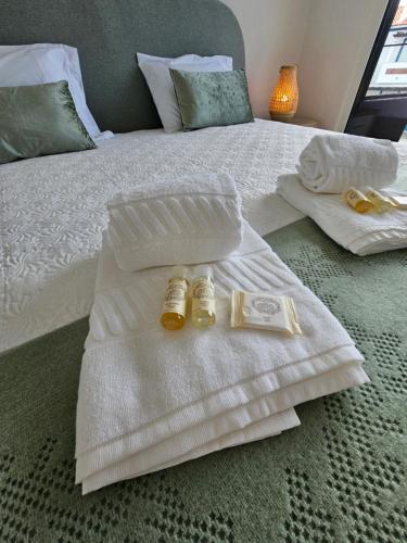 a bed with two towels and two bottles on it at Beach House by the Lagoon - Piscina Privada in Casal do Narcizo