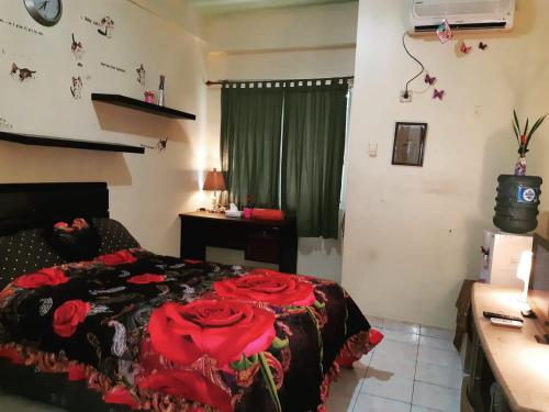- une chambre avec un lit et une couverture rouge dans l'établissement Margonda residence 1& 2 by andrew, à Pondokcina